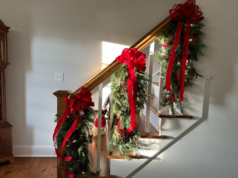 A home staircase is decorated with garland for Christmas