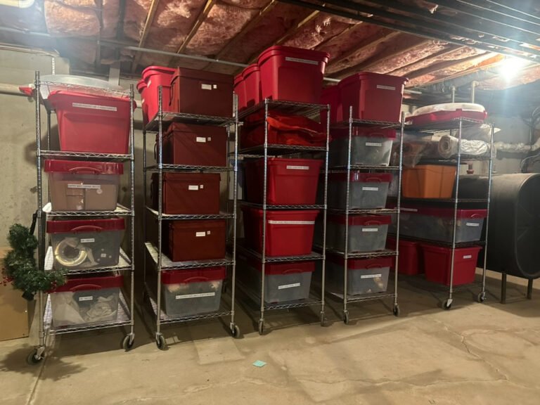A basement has neatly stacked containers of Christmas items.
