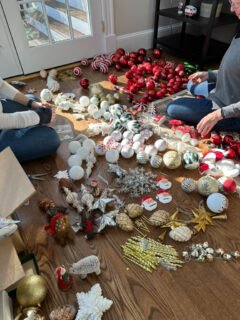 An assortment of Christmas ornaments are laid out neatly on a floor.