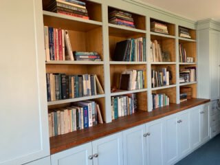A beautifully organized bookshelf is staged for a home sale.