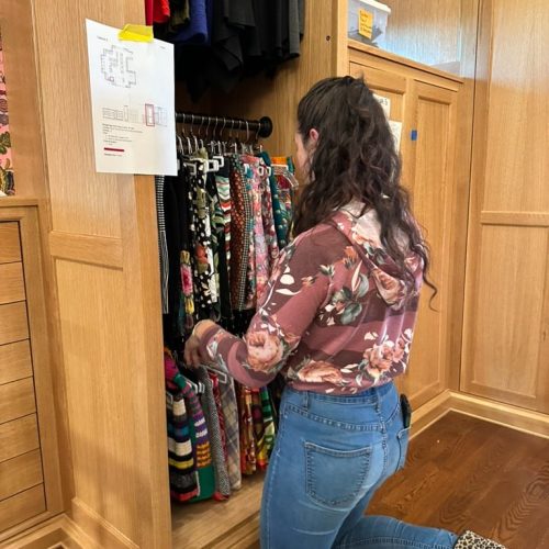 A professional organizer is sorting out a closet cobby hole.