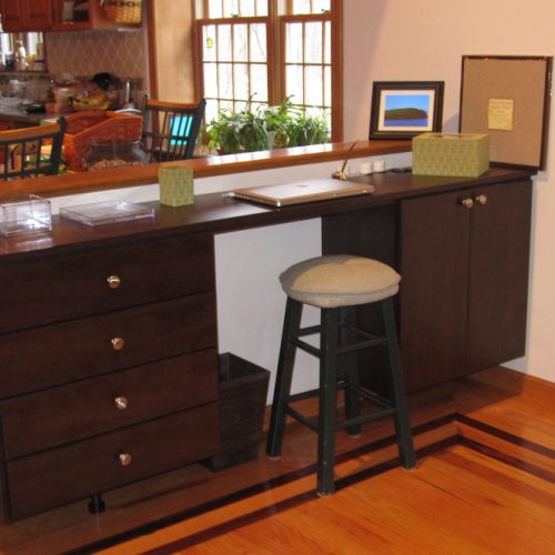 A small desk next to a kitchen area provides an area for organization - an organized life, ma