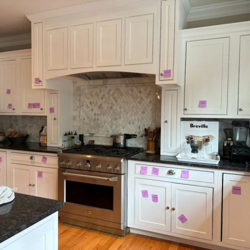 A kitchen is prepared for a move by having it's cabinets labeled for items.