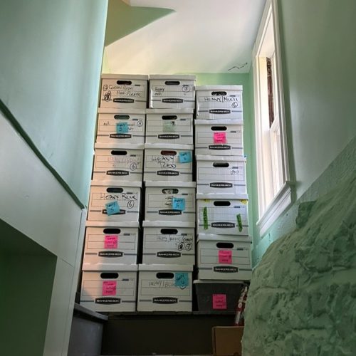 A stacked pile of boxes stand at the top of a staircase - an organized life, ma