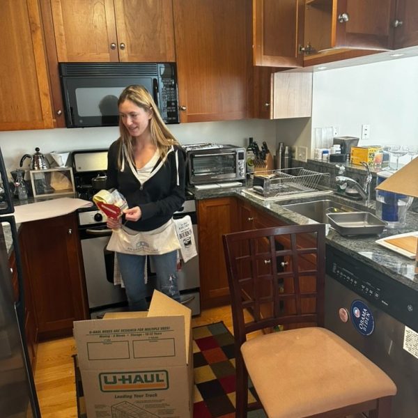 An Organized Life staff is boxing up glasses in a kitchen for a move.