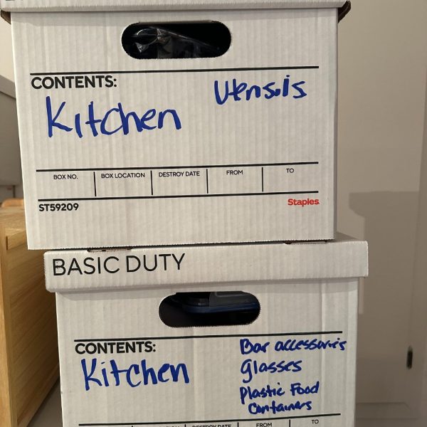 A stack of white boxes with kitchen utensils.