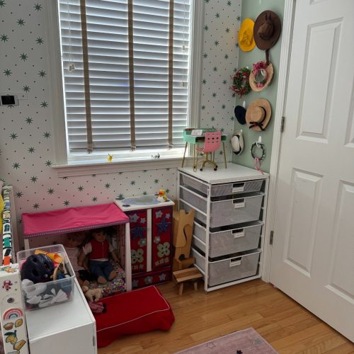 A child's room is delightfully organized with bins and wall pegs - an organized life, ma